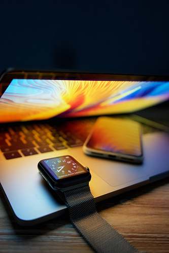 computer hardware iPhone and Apple Watch on MacBook Pro computer keyboard